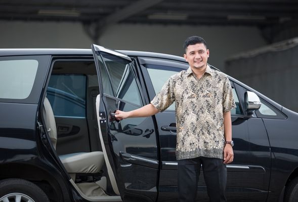 Sopir Aryabima membukakan pintu untuk penumpang